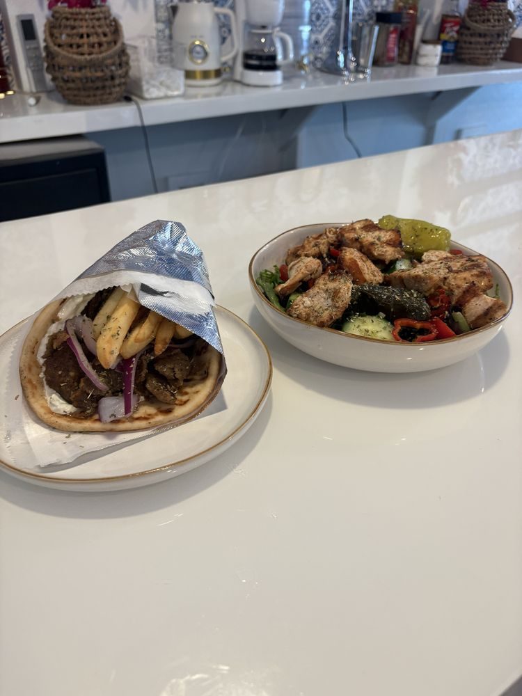 Wrapped gyro with fries and a grilled chicken Greek salad bowl at Ellada Mediterranean Grill